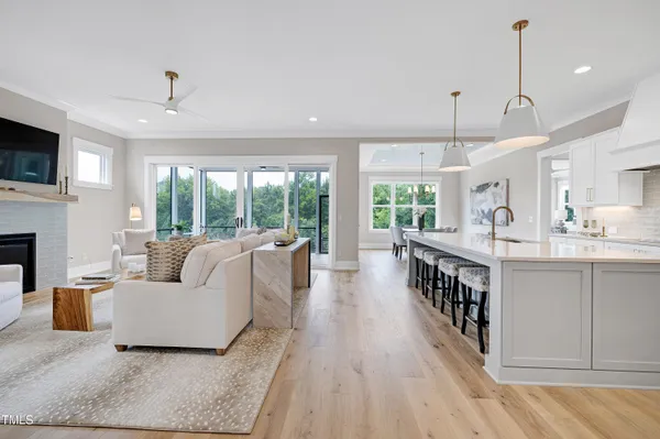a living room with furniture a flat screen tv and a floor to ceiling window