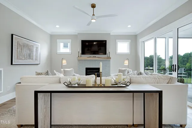a living room with furniture a flat screen tv and a floor to ceiling window