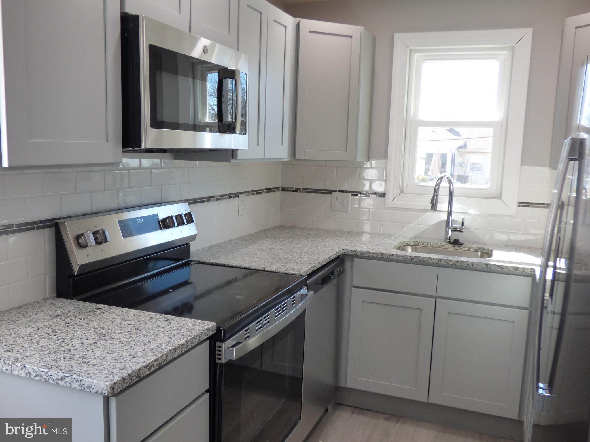 726 Newportville Road Croydon, PA 19021 - Photo 18 of 30 a kitchen with a sink stove and microwave