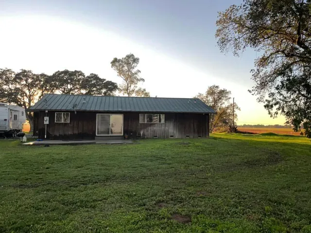 a view of a lush green field with a mountain in the background