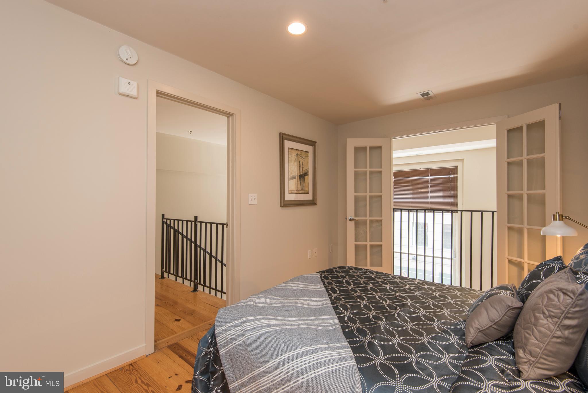 1200 Walnut Street, Unit 203 Philadelphia, PA 19107 - Photo 20 of 27 a bedroom with a bed and wooden floor