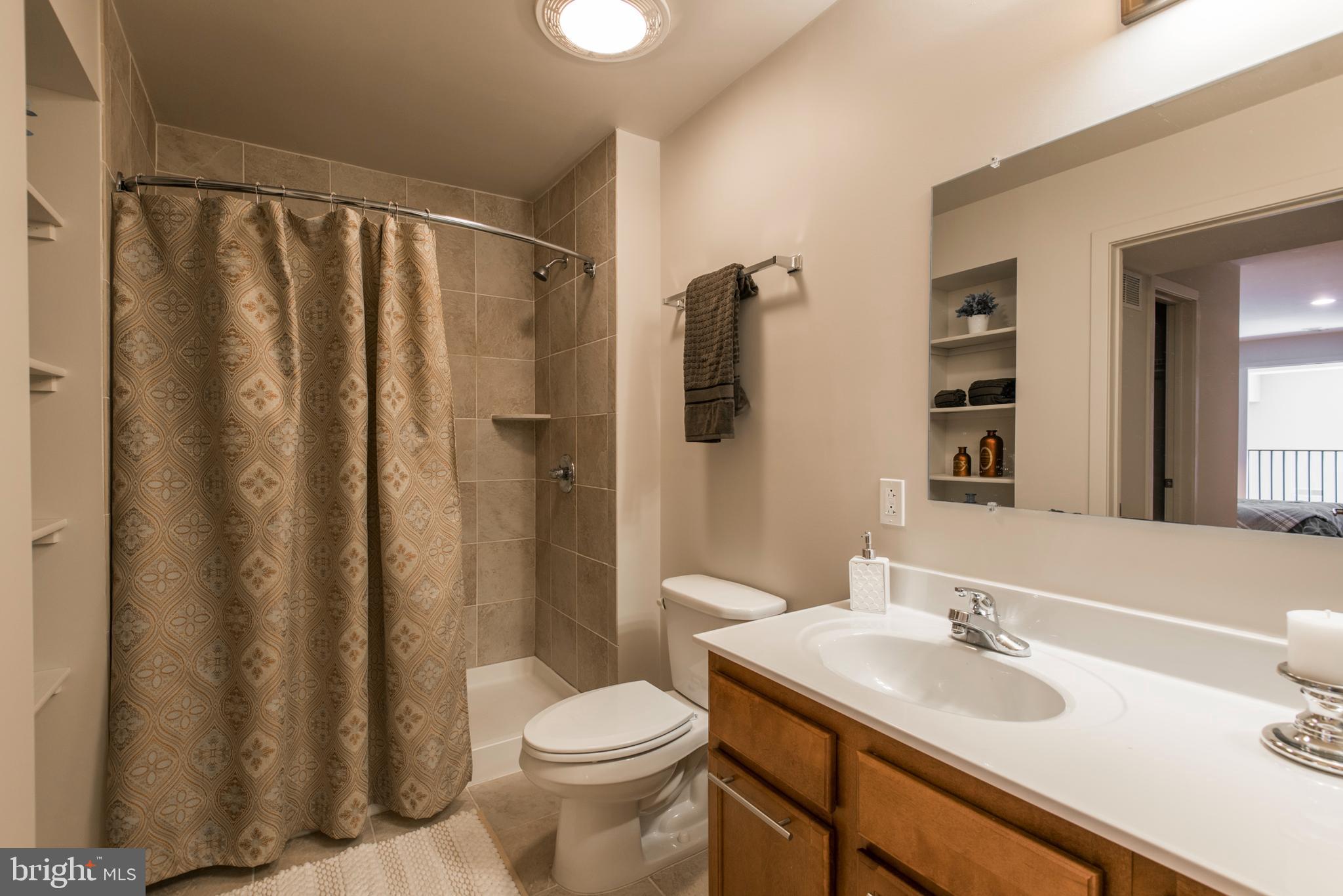 1200 Walnut Street, Unit 203 Philadelphia, PA 19107 - Photo 10 of 27 a bathroom with a sink a toilet a mirror and shower curtain