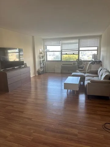 a living room with furniture and hard wood flooring