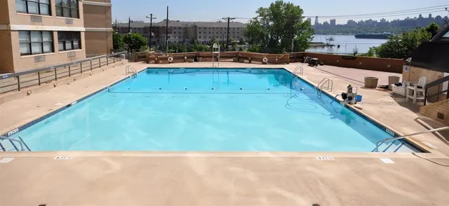 a view of swimming pool with outdoor seating and a pathway