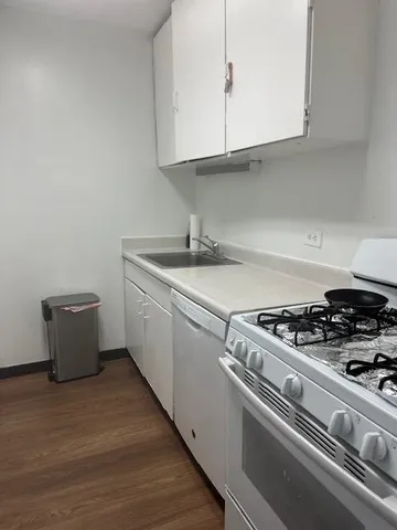 a kitchen with a stove and white cabinets
