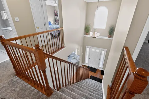a view of a hallway with wooden floor and stairs
