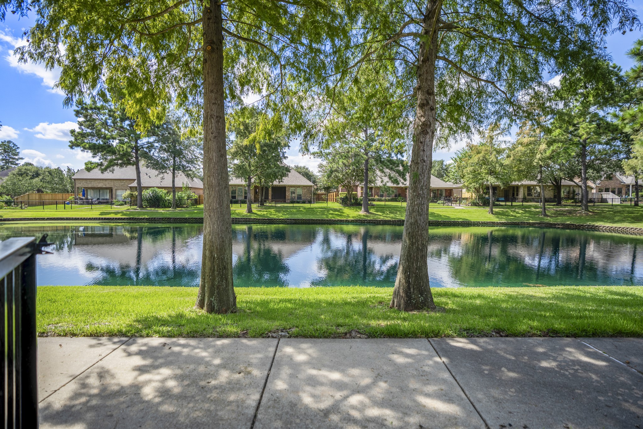 2407 Hendricks Lakes Drive Spring, TX 77388 - Photo 41 of 50 From the trail just beyond the backyard, the Lakes of Cypress Forest setting feels peaceful and scenic, with water views, mature trees, and green space stretching along the path. This is the lifestyle piece buyers can feel outside the fence line — morning walks, shaded views, and a water-front backdrop that extends the backyard experience into the neighborhood.