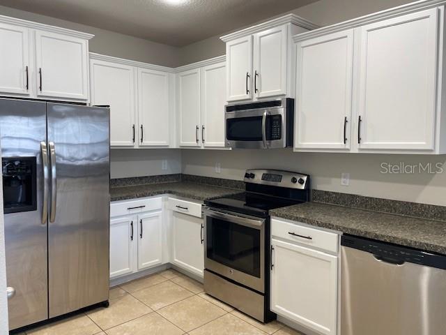 6536 South Goldenrod Road, Unit 67A Orlando, FL 32822 - Photo 4 of 14 a kitchen with granite countertop white cabinets and stainless steel appliances