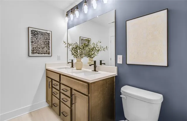 a bathroom with a toilet sink and mirror