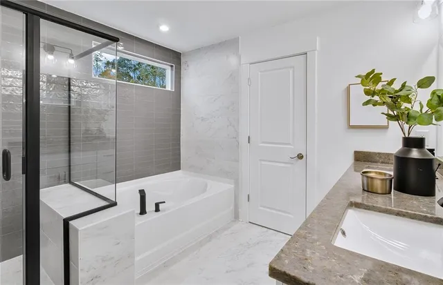 a bathroom with a tub sink and mirror