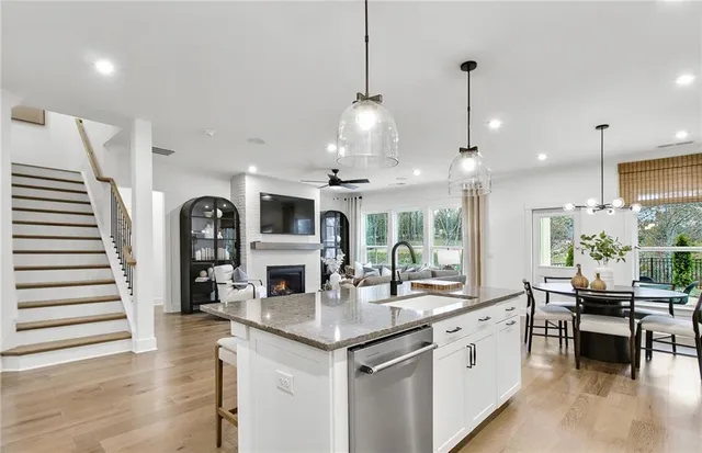 a open kitchen with stainless steel appliances granite countertop living room and couches with wooden floor