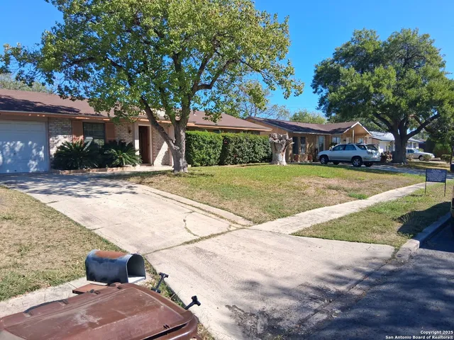 a front view of a house with a yard and potted plants