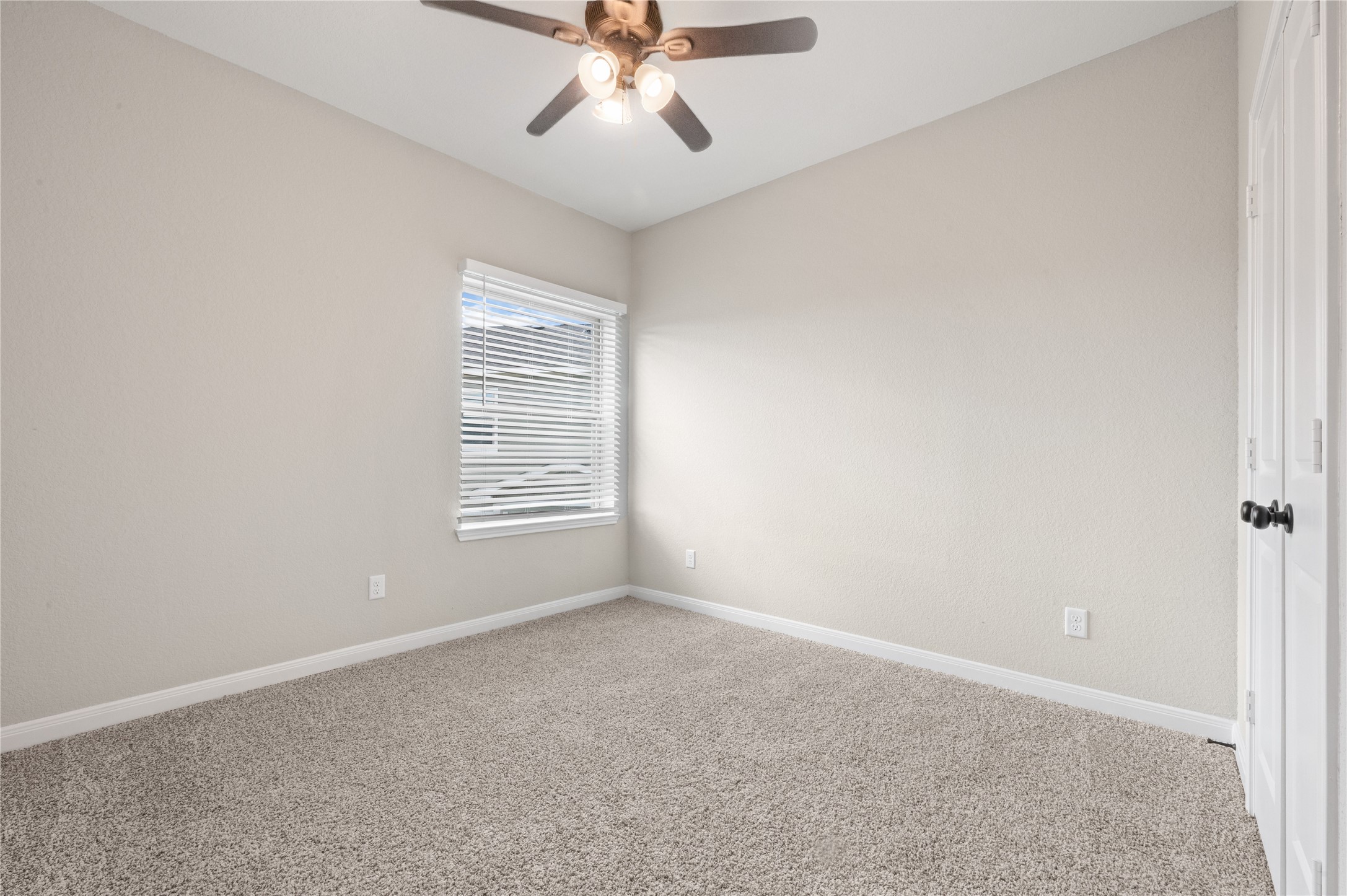 14010 Longstreet Road, Unit 2 Willis, TX 77318 - Photo 10 of 29 This room features neutral walls, a cozy carpet, and a ceiling fan with lights. A window with blinds provides natural light, and there's a closet with double doors. Ideal for a bedroom or office space.