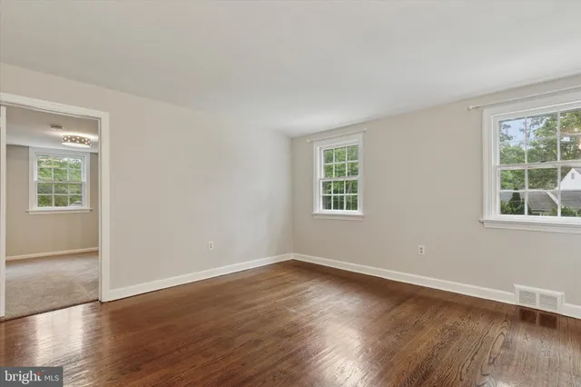 a view of a room with wooden floor and windows