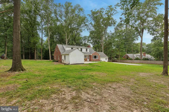 a view of a house with backyard and a tree