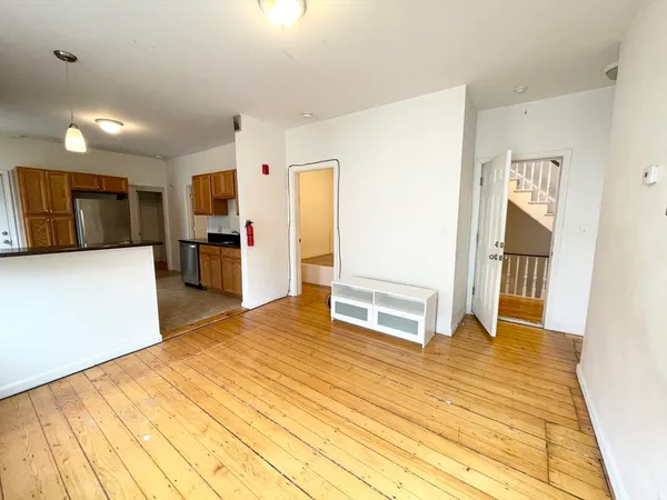 a living room with stainless steel appliances kitchen island sink refrigerator and stove