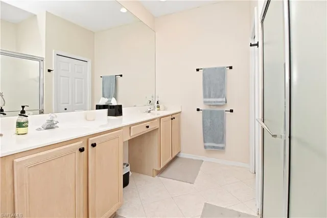 a bathroom with a double vanity sink a mirror and a shower