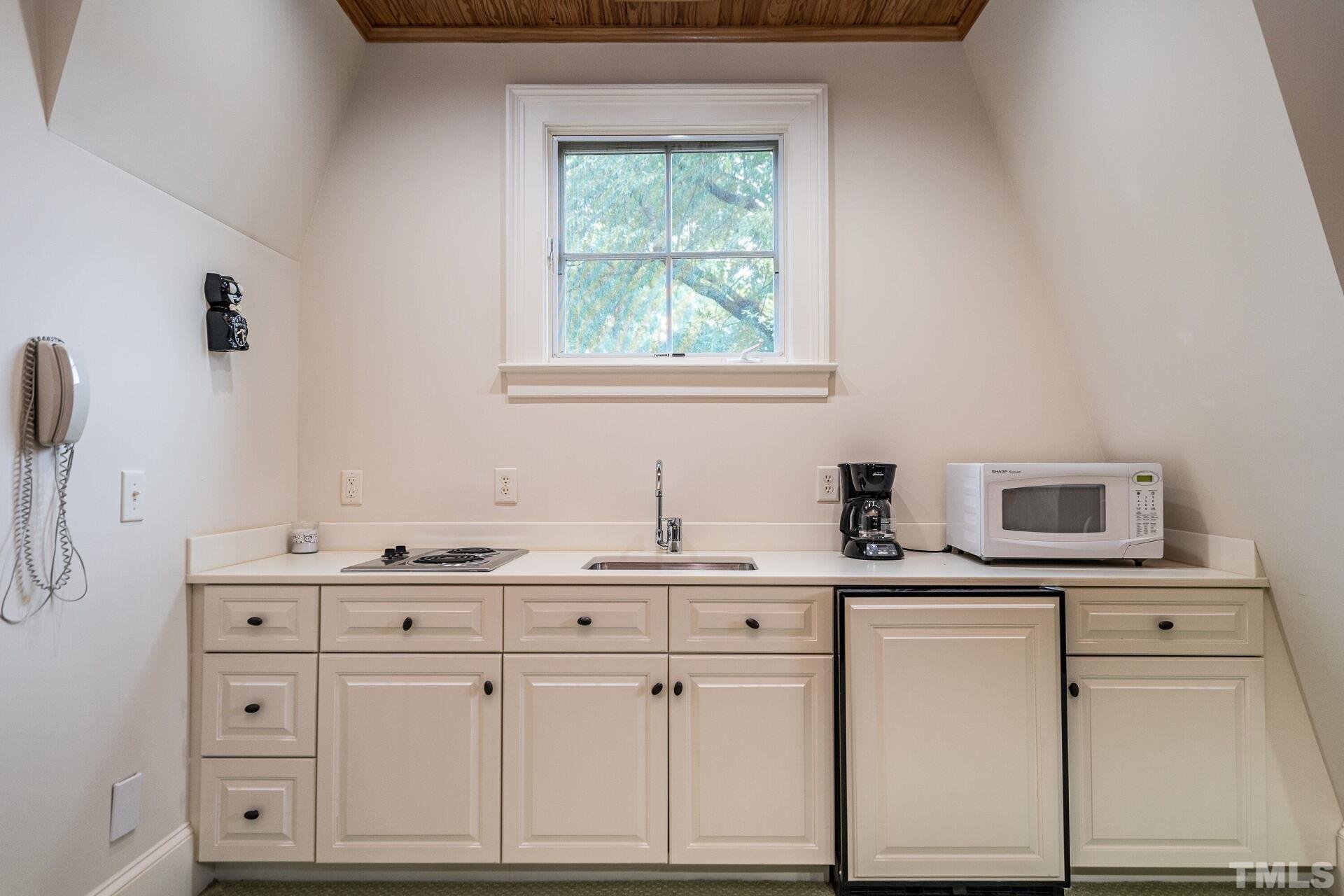1027 Vance Street Raleigh, NC 27608 - Photo 31 of 42 a kitchen with cabinets appliances a sink and a window