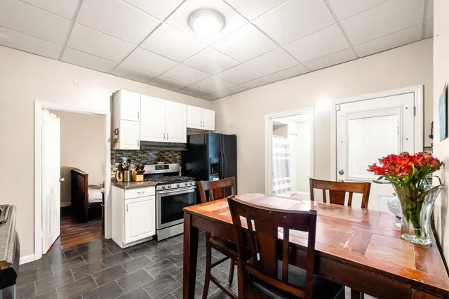 a kitchen with a table chairs refrigerator and microwave
