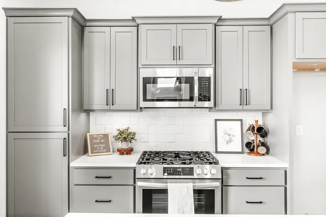 a kitchen with stainless steel appliances white cabinets and a stove