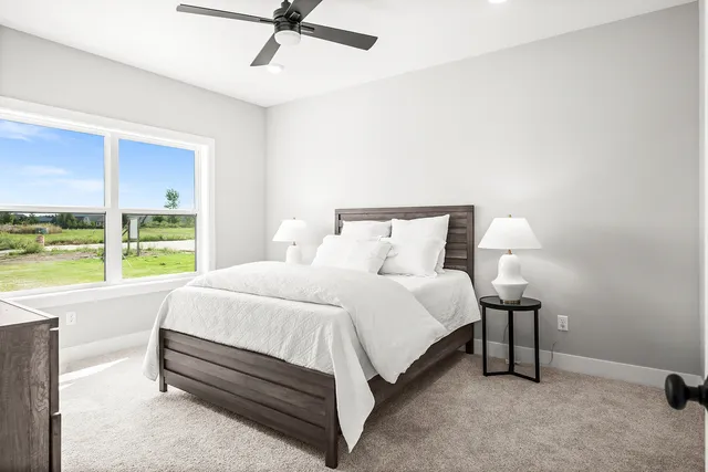 a bedroom with a bed and large window