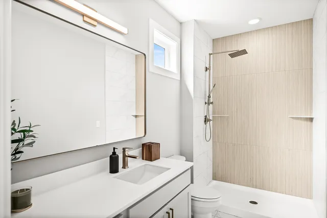 a bathroom with a sink a toilet and shower