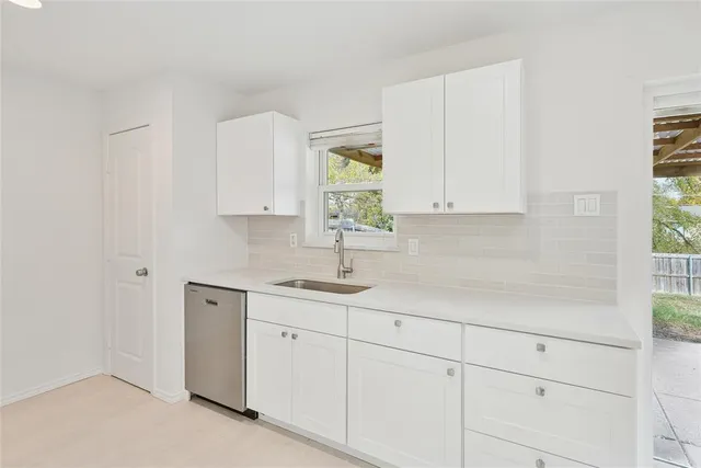 a large white kitchen with a sink
