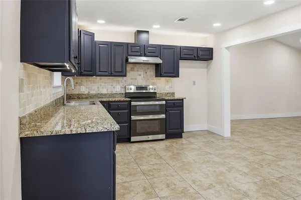 a kitchen with stainless steel appliances granite countertop a stove a sink and a microwave