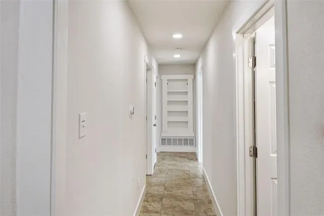 a view of a hallway with wooden shelves