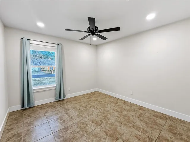 an empty room with fan and windows