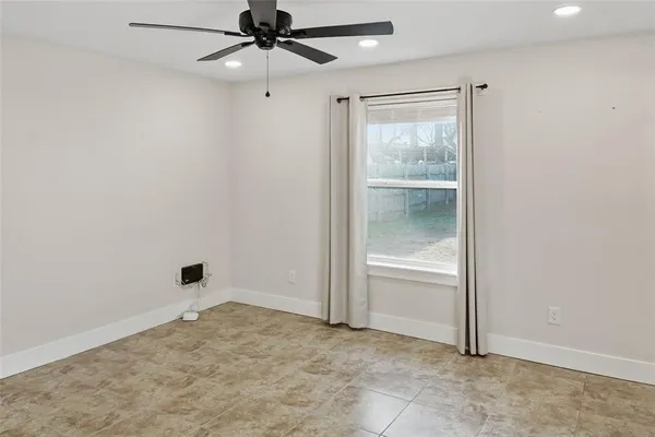 an empty room with a window and a fan