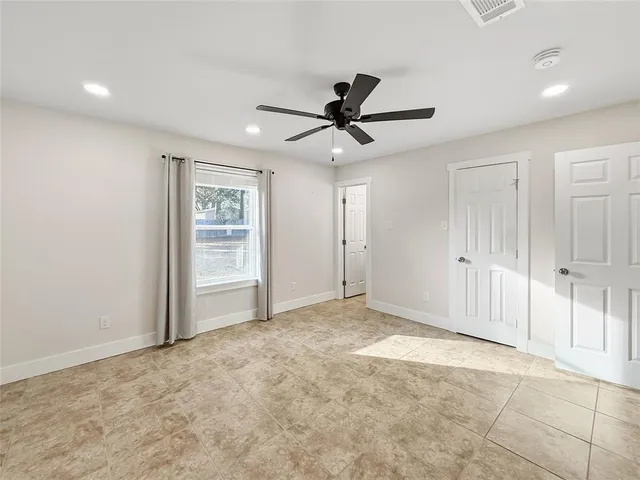 a view of an empty room and a ceiling fan window