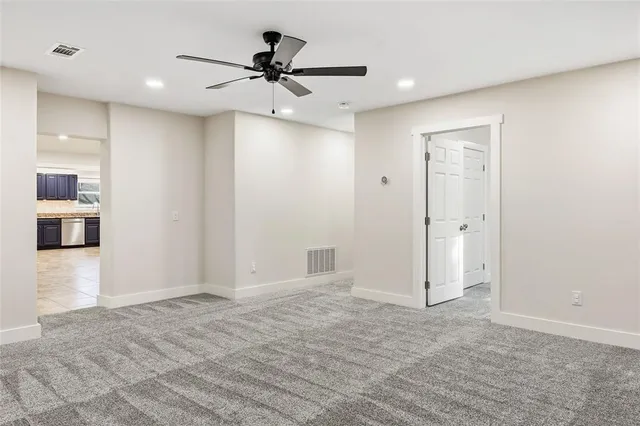 a view of a livingroom with a ceiling fan and kitchen space