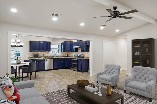 a living room with furniture kitchen view and a chandelier