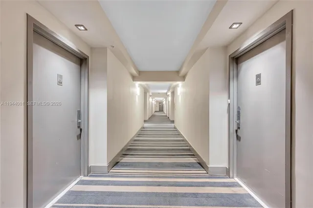 a view of a hallway with wooden floor and entryway