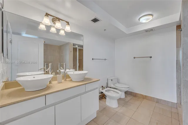 a spacious bathroom with a toilet sink and a mirror
