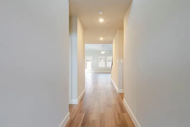 a view of a hallway with wooden floor