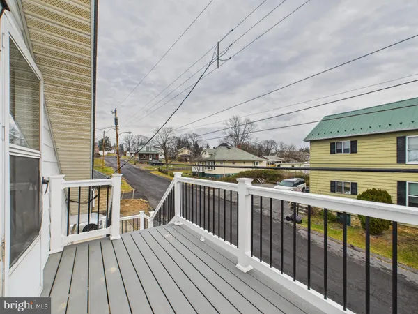 a view of a balcony with wooden floor and fence