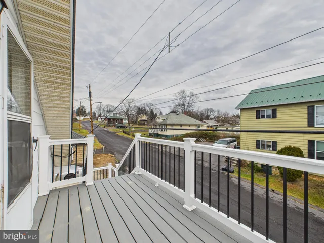 a view of a balcony with wooden floor and fence