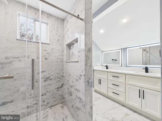 a bathroom with a granite countertop sink a toilet and shower