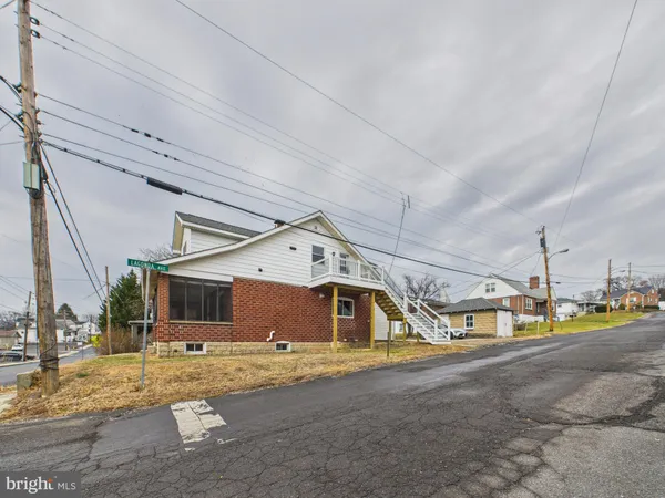 a view of a house with a big yard and a large tree