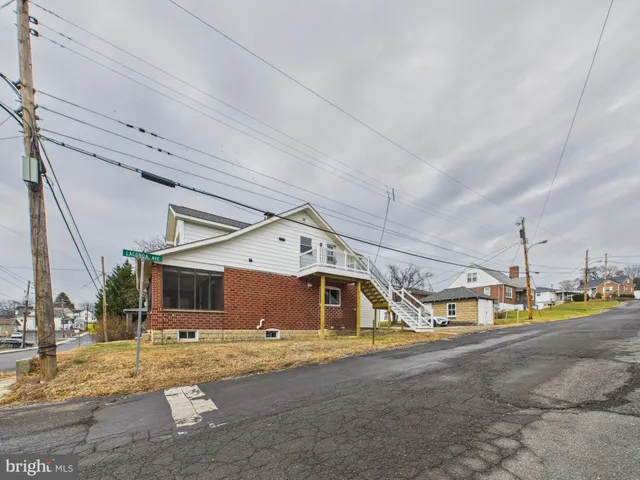 a view of a house with a big yard and a large tree