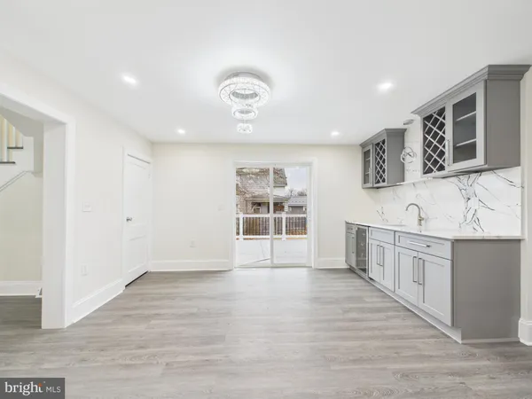 a view of kitchen with stainless steel appliances wooden floor and cabinets