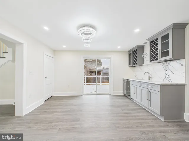 a view of kitchen with stainless steel appliances wooden floor and cabinets