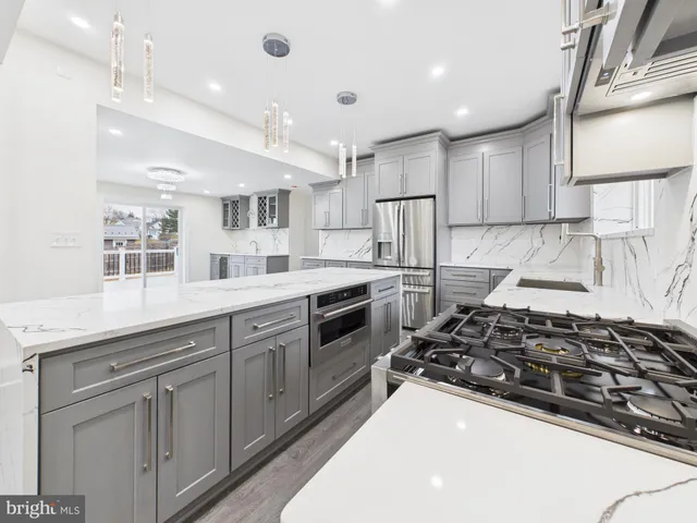 a kitchen with stainless steel appliances a sink stove and cabinets