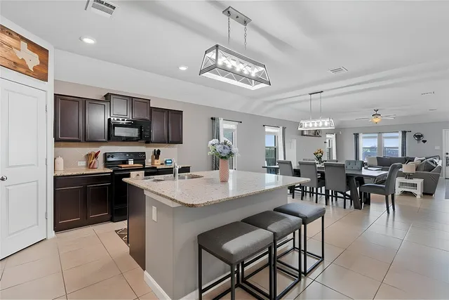 a view of kitchen with sink dining table and chairs