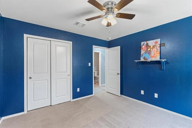 en empty room with windows and fan