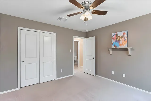 an empty room with chandelier fan