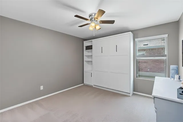 an empty room with cabinet and a ceiling fan