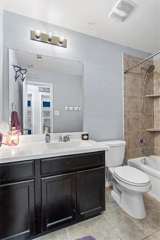 a bathroom with a toilet sink double vanity and mirror